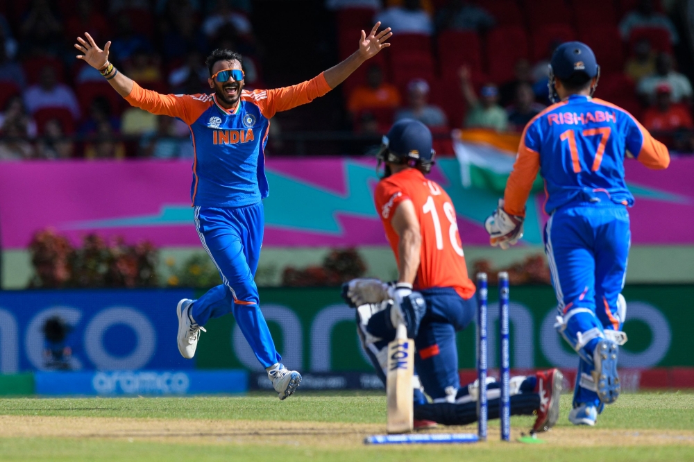 Axar Patel (left) of India celebrates the dismissal of Moeen Ali of England during the ICC men's Twenty20 World Cup 2024 semi-final cricket match between India and England at Providence Stadium in Georgetown, Guyana, on June 27, 2024. (Photo by Randy Brooks / AFP)