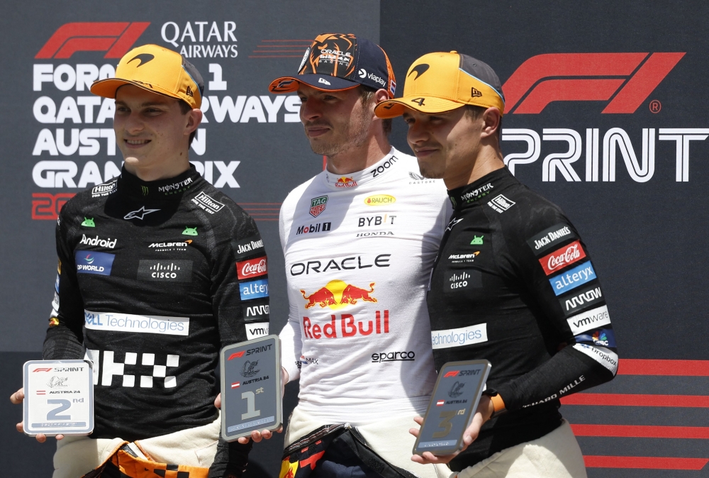 (L-R) Second placed McLaren's Australian driver Oscar Piastri, winner Red Bull Racing's Dutch driver Max Verstappen and third placed McLaren's British driver Lando Norris in Spielberg, Austria, on June 29, 2024. (Photo by Erwin Scheriau / APA / AFP)