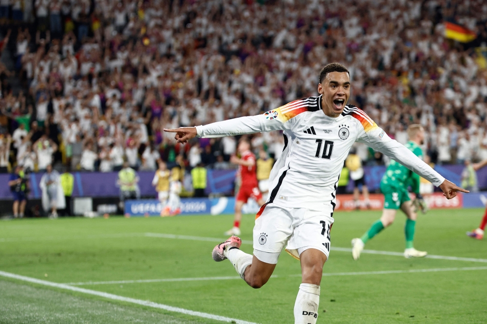 Germany's midfielder #10 Jamal Musiala celebrates scoring his team's second goal during the UEFA Euro 2024 round of 16 football match between Germany and Denmark at the BVB Stadion Dortmund in Dortmund on June 29, 2024. (Photo by KENZO TRIBOUILLARD / AFP)
