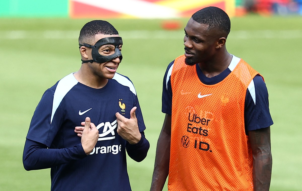 France's forward #10 Kylian Mbappe (L) jokes with France's forward #15 Marcus Thuram during a training session at the Home Deluxe Arena Stadium in Paderborn, western Germany, on June 27, 2024, during the UEFA EURO 2024 football competition. Photo by FRANCK FIFE / AFP