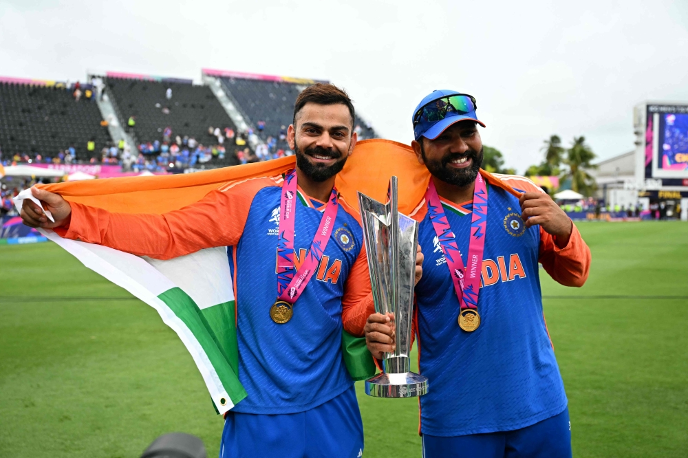 India's Virat Kohli and captain Rohit Sharma celebrate with the trophy on June 29, 2024. (Photo by Chandan Khanna / AFP)
 