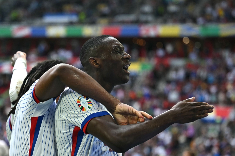 France's forward #12 Randal Kolo Muani (R) celebrates scoring his team's first goal during the UEFA Euro 2024 round of 16 football match between France and Belgium at the Duesseldorf Arena in Duesseldorf on July 1, 2024. (Photo by OZAN KOSE / AFP)
