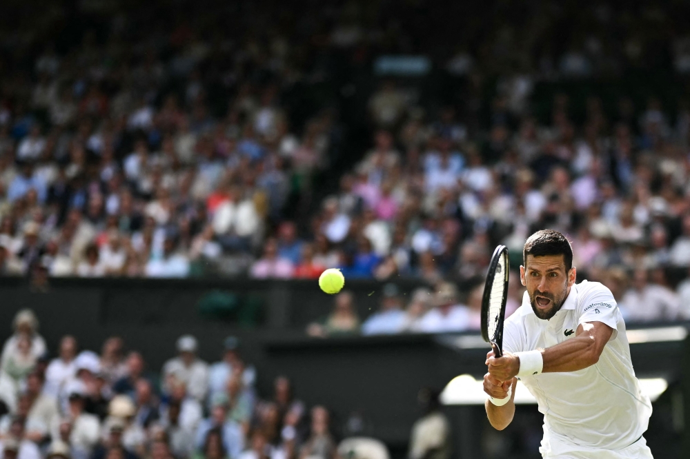 Serbia's Novak Djokovic returns the ball to Britain's Jacob Feamley during their men's singles tennis match on the fourth day of the 2024 Wimbledon Championships at The All England Lawn Tennis and Croquet Club in Wimbledon, southwest London, on July 4, 2024. (Photo by Ben Stansall / AFP) 