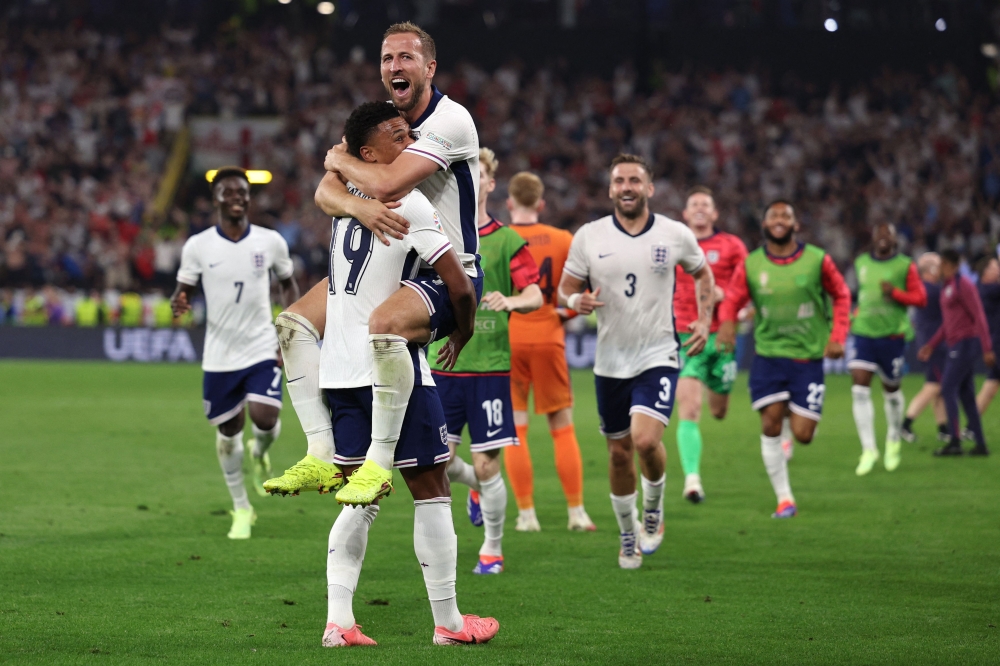 England's forward #09 Harry Kane (up) celebrates with England's forward #19 Ollie Watkins after winning the UEFA Euro 2024 semi-final football match between the Netherlands and England at the BVB Stadion in Dortmund on July 10, 2024. (Photo by Adrian Dennis / AFP)