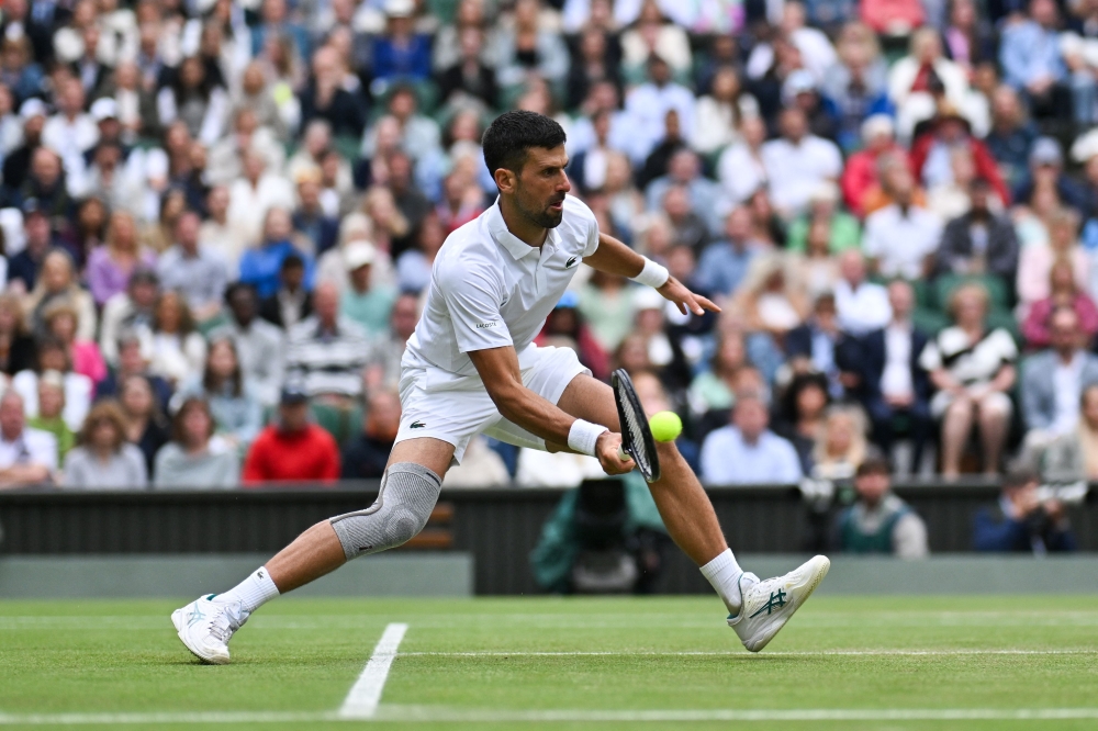 Serbia's Novak Djokovic returns against Italy's Lorenzo Musetti on July 12, 2024. (Photo by Andrej Isakovic / AFP) 
 