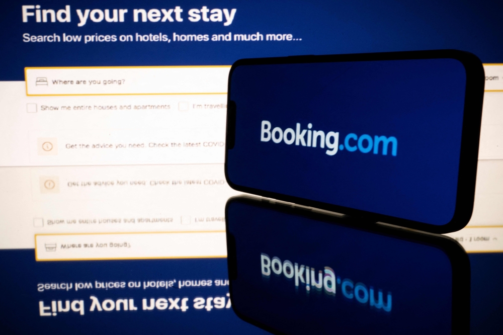 (FILES) This file photo shows screens displaying the logo and the website of the online travel and accommodation services platform Booking.com in Toulouse, southwestern France on January 25, 2023. (Photo by Lionel BONAVENTURE / AFP)
