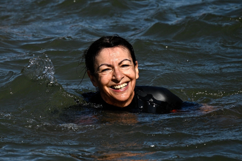 Paris Mayor Anne Hidalgo swims in the Seine, in Paris on July 17, 2024, to demonstrate that the river is clean enough to host the outdoor swimming events at the Paris Olympics later this month. Photo by JULIEN DE ROSA / AFP