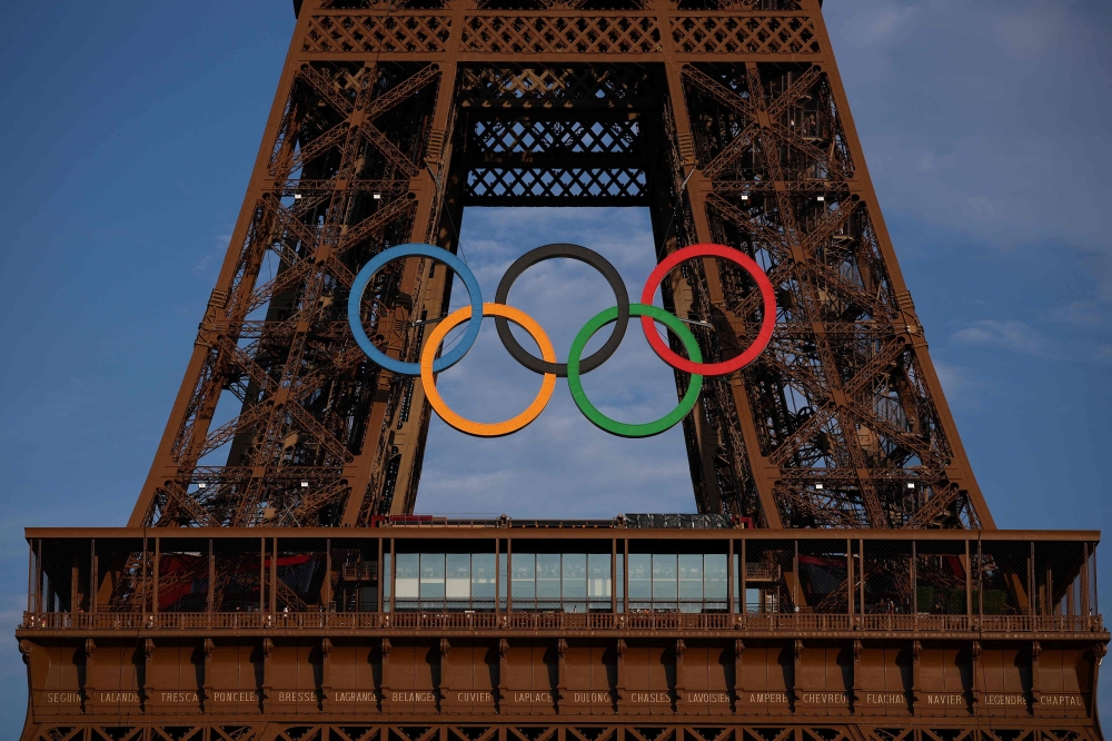 This photograph shows the Eiffel Tower, decorated with the Olympic rings for the upcoming Paris 2024 Olympic Games, in Paris, on July 18, 2024. (Photo by EMMANUEL DUNAND / AFP)