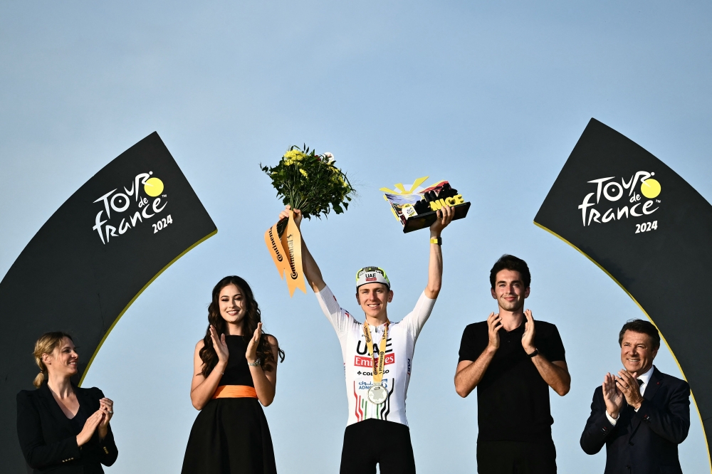 UAE Team Emirates team's Slovenian rider Tadej Pogacar celebrates on the podium after winning the 21st and final stage of the 111th edition of the Tour de France cycling race, a 33,7 km individual time-trial between Monaco and Nice, on July 21, 2024. (Photo by Marco BERTORELLO / AFP)
