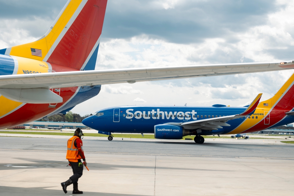 A ramp agent walks past a Southwest Airlines Boeing 737-700 airplane in Baltimore. (Photo by Angus Mordant/Bloomberg)