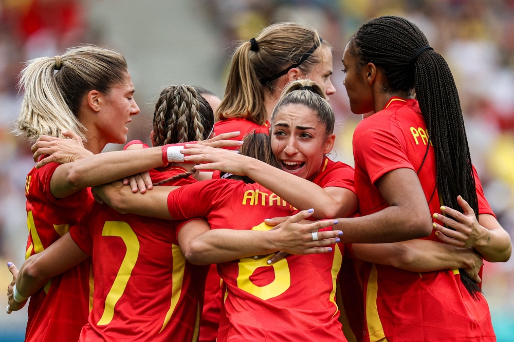 Spain's midfielder #06 Aitana Bonmati celebrates with teammates after scoring her team's first goal in the women's group C football match between Spain and Japan during the Paris 2024 Olympic Games at La Beaujoire Stadium in Nantes on July 25, 2024. (Photo by Alain Jocard / AFP)