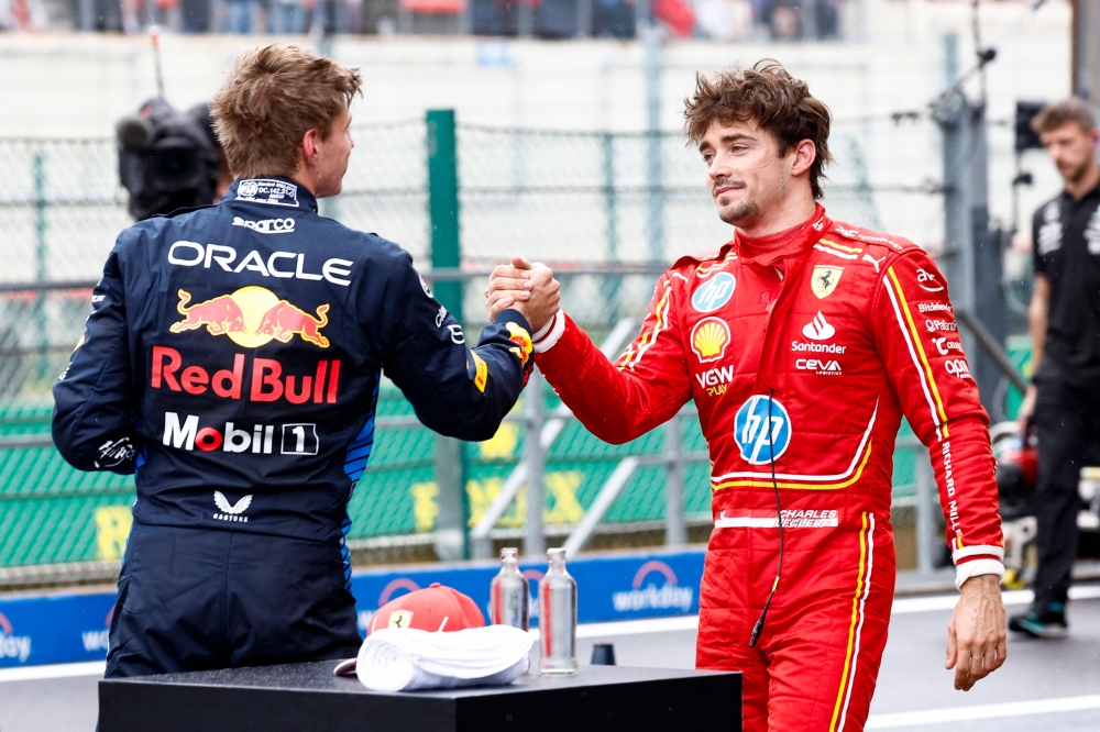 Red Bull Racing's Dutch driver Max Verstappen (L) shakes hands with Ferrari's Monegasque driver Charles Leclerc after the qualifying session ahead of the Formula One Belgian Grand Prix at the Spa-Francorchamps Circuit in Spa on July 27, 2024. (Photo by SIMON WOHLFAHRT / AFP)
