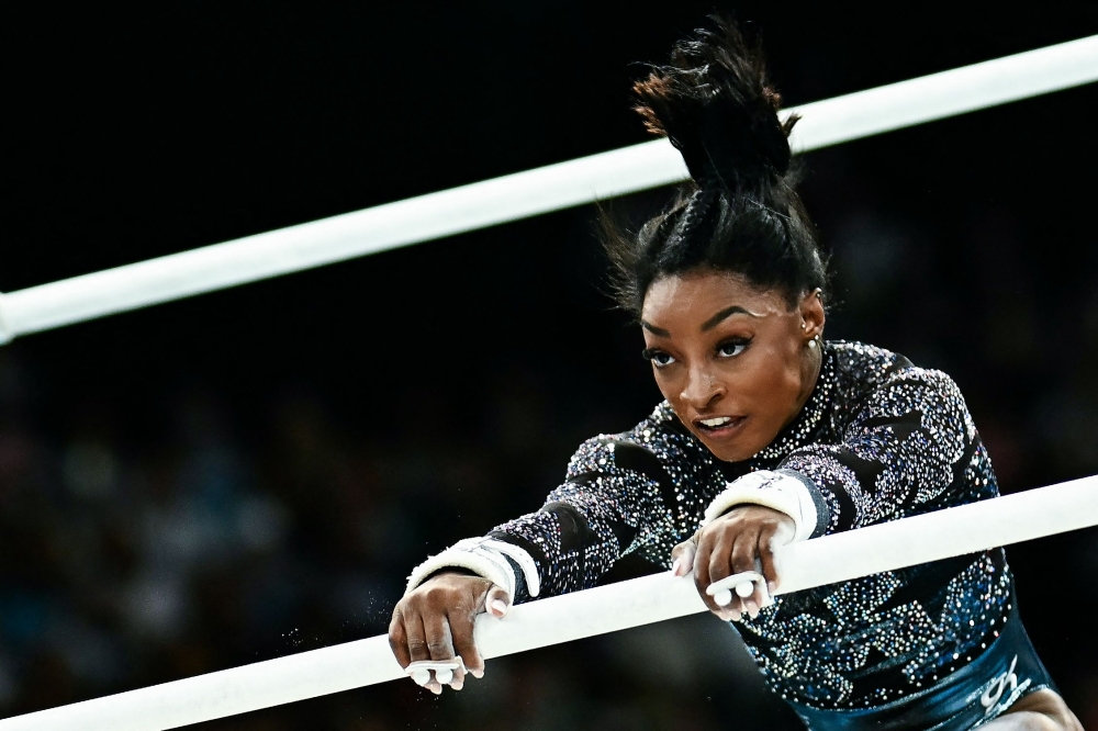 US' Simone Biles competes in the uneven bars event of the artistic gymnastics women's qualification during the Paris 2024 Olympic Games at the Bercy Arena in Paris, on July 28, 2024. (Photo by Loic VENANCE / AFP)