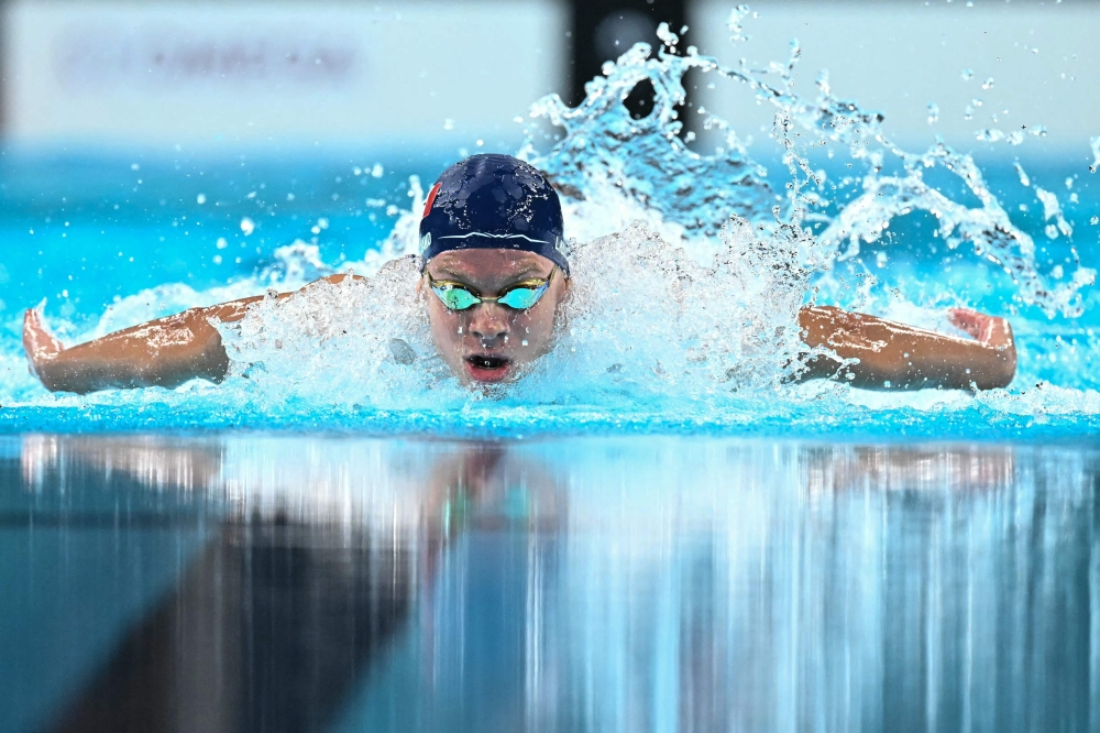 France's Leon Marchand competes in the final of the men's 400m individual medley swimming event during the Paris 2024 Olympic Games at the Paris La Defense Arena in Nanterre, west of Paris, on July 28, 2024. (Photo by Manan VATSYAYANA / AFP)
