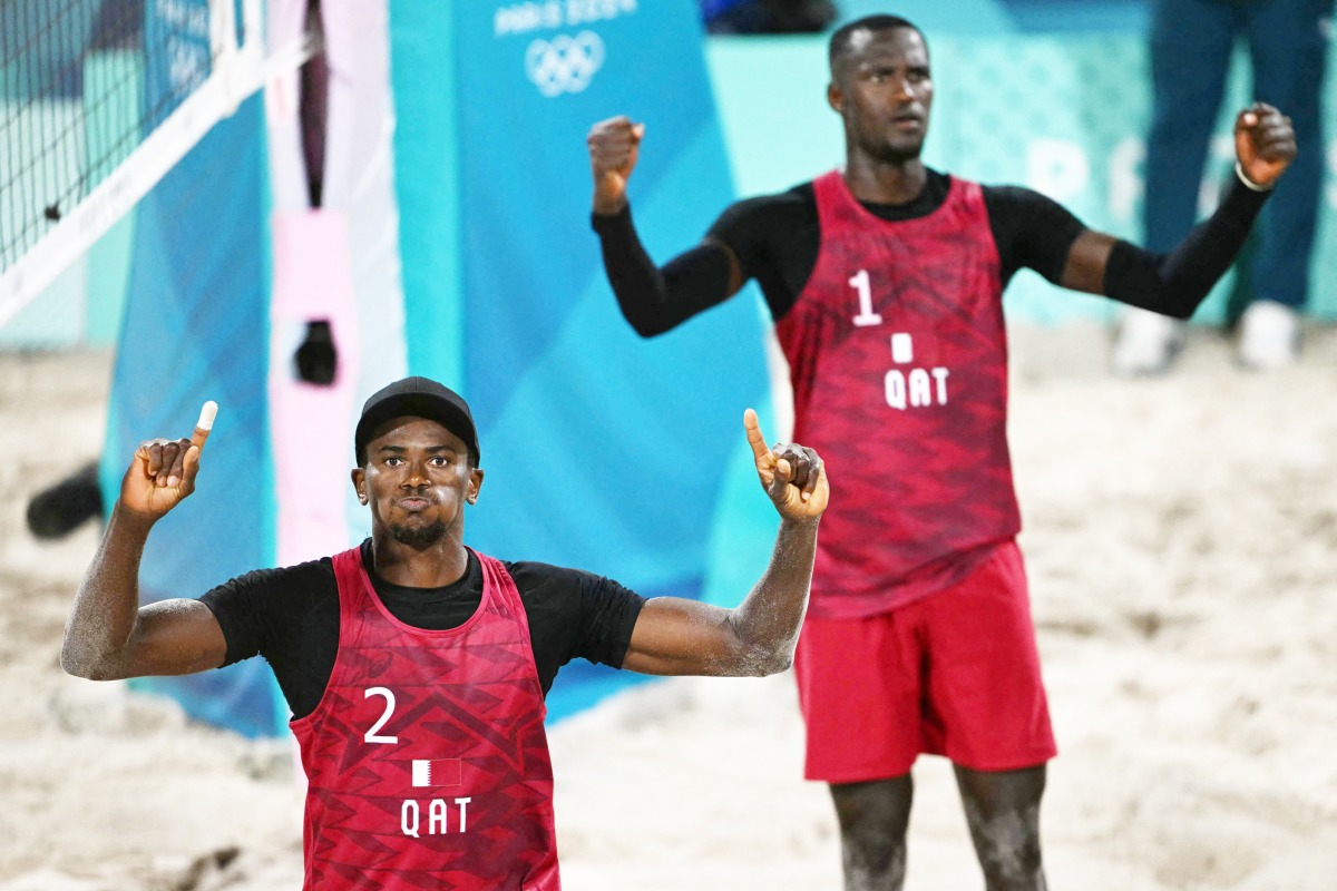 Qatar’s Ahmed Tijan (left) and Cherif Younousse celebrate after scoring a point in the men’s pool A beach volleyball match against Italy's Paolo Nicolai and Samuele Cottafava. AFP