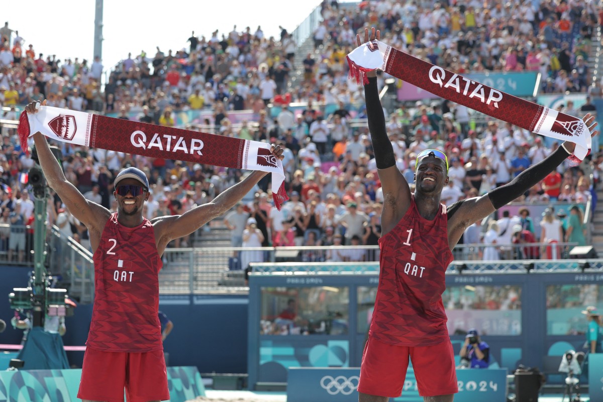 Qatar's #02 Ahmed Tijan and Qatar's #01 Cherif Younousse celebrate their victory in the men's pool A beach volleyball match between Qatar and Australia during the Paris 2024 Olympic Games at the Eiffel Tower Stadium in Paris on August 1, 2024. Photo by Thomas SAMSON / AFP.