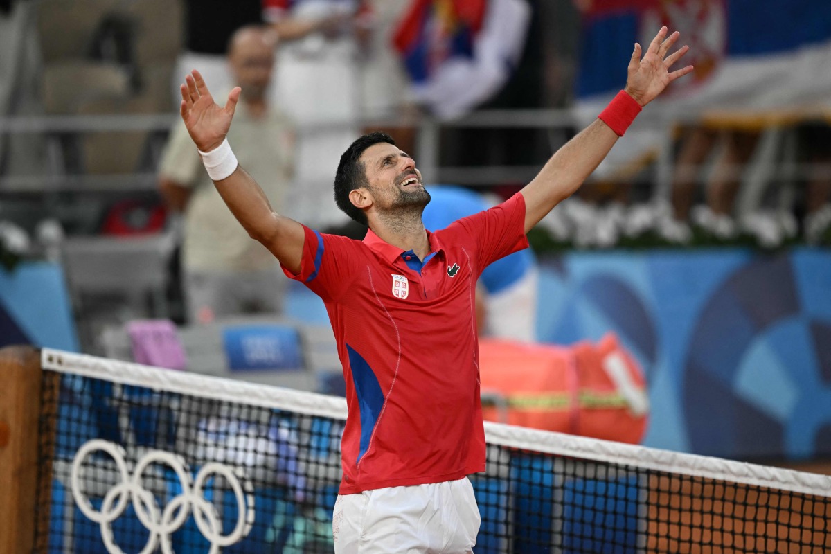 Serbia's Novak Djokovic celebrates beating Italy's Lorenzo Musetti during their men's singles semi-final tennis match on Court Philippe-Chatrier at the Roland-Garros Stadium during the Paris 2024 Olympic Games, in Paris on August 2, 2024. (Photo by CARL DE SOUZA / AFP)