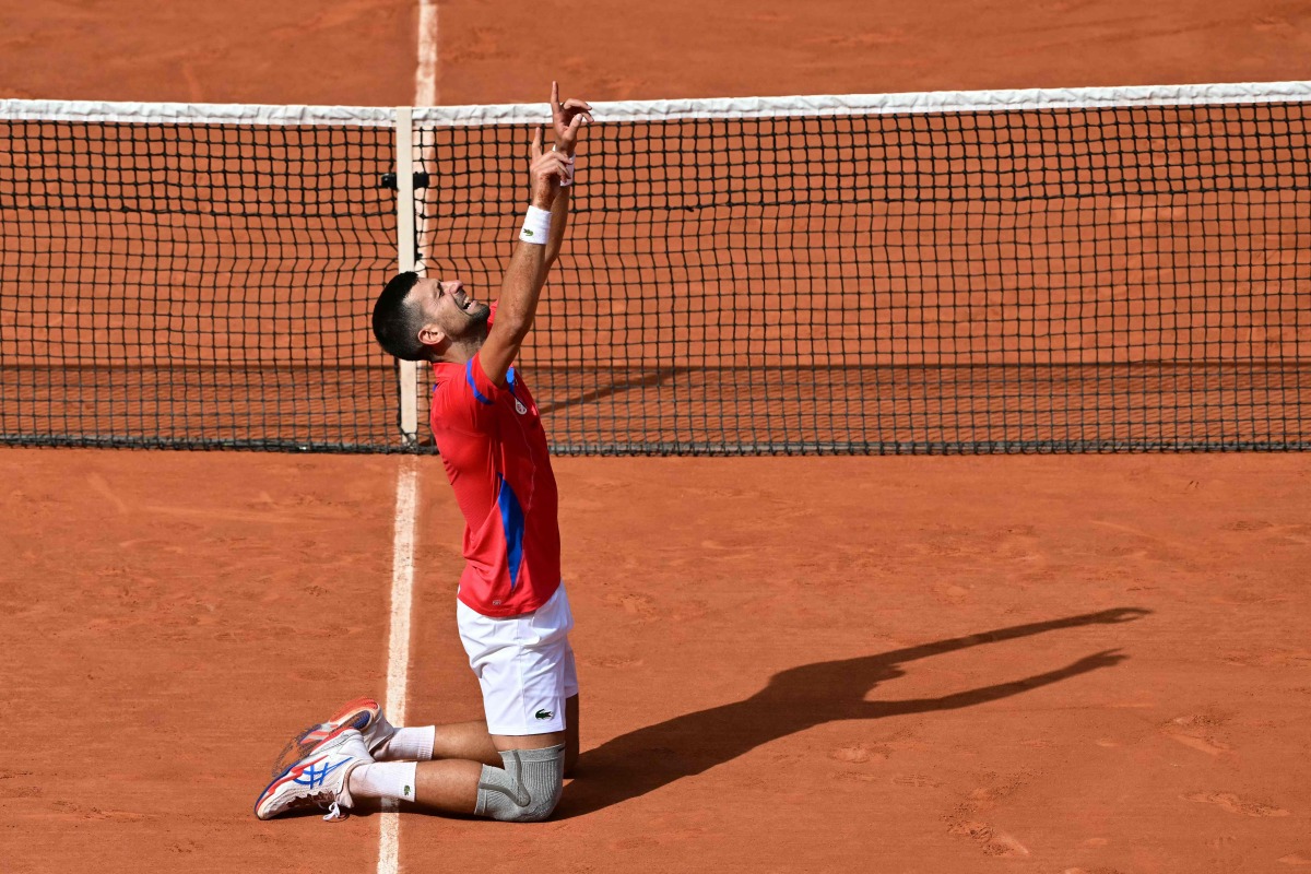 Serbia's Novak Djokovic reacts to beating Spain's Carlos Alcaraz in their men's singles final tennis match on Court Philippe-Chatrier at the Roland-Garros Stadium during the Paris 2024 Olympic Games, in Paris on August 4, 2024. (Photo by Miguel MEDINA / AFP)
