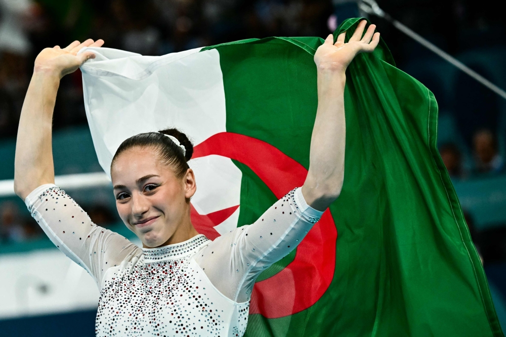 Algeria's Kaylia Nemour celebrates after winning the artistic gymnastics women's uneven bars final during the Paris 2024 Olympic Games at the Bercy Arena in Paris, on August 4, 2024. (Photo by Loic VENANCE / AFP)
