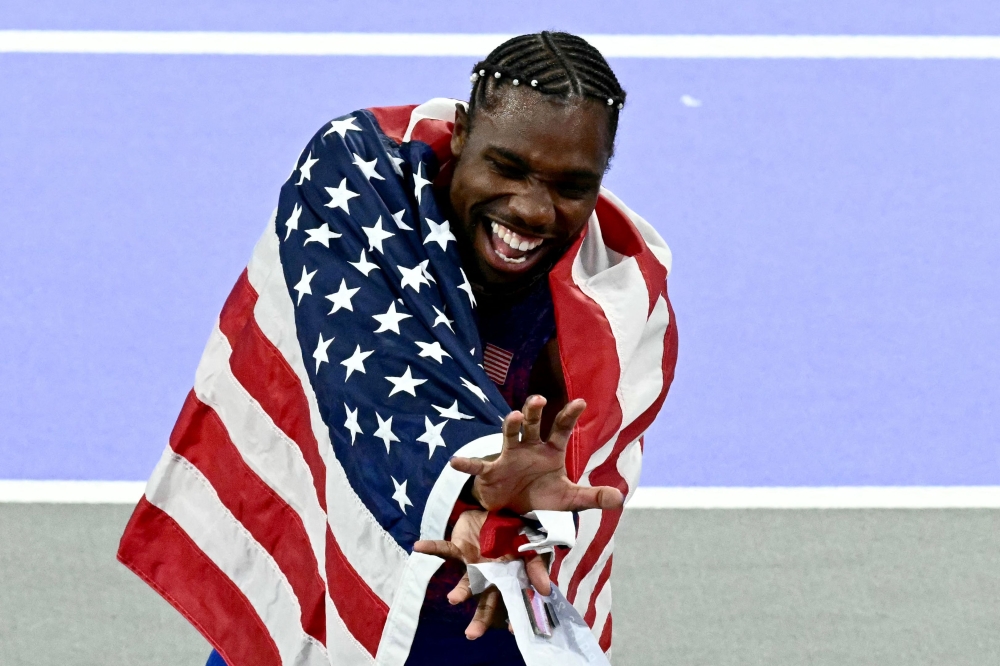 US' Noah Lyles celebrates after winning the men's 100m final of the athletics event at the Paris 2024 Olympic Games at Stade de France in Saint-Denis, north of Paris, on August 4, 2024. (Photo by Loic VENANCE / AFP)
