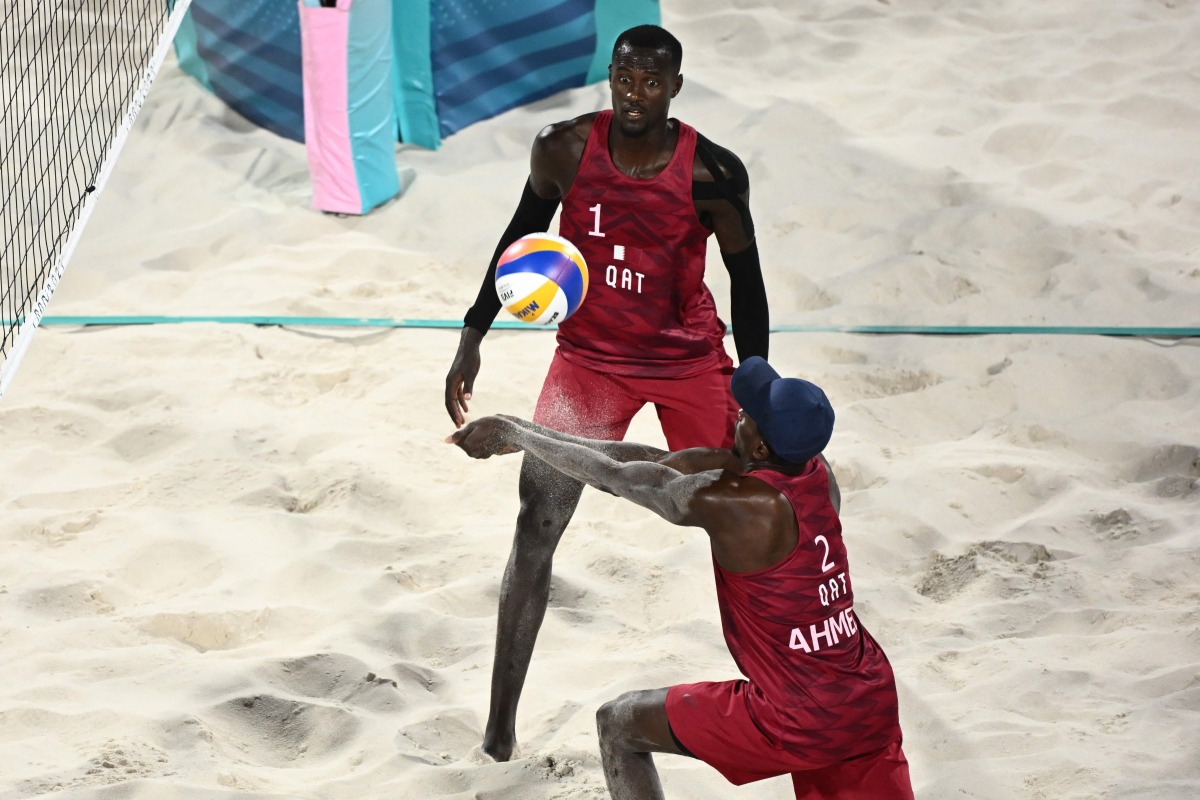 Qatar’s Ahmed Tijan (right) digs the ball beside Cherif Younousse during their Round of 16 match against Chile. AFP