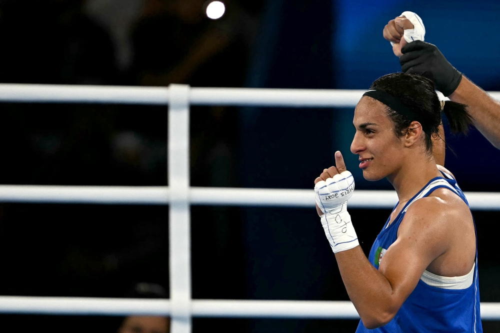 Algeria's Imane Khelif (Blue) reacts after beating Thailand's Janjaem Suwannapheng in the women's 66kg semi-final boxing match during the Paris 2024 Olympic Games at the Roland-Garros Stadium, in Paris on August 6, 2024. (Photo by Mauro PIMENTEL / AFP)
