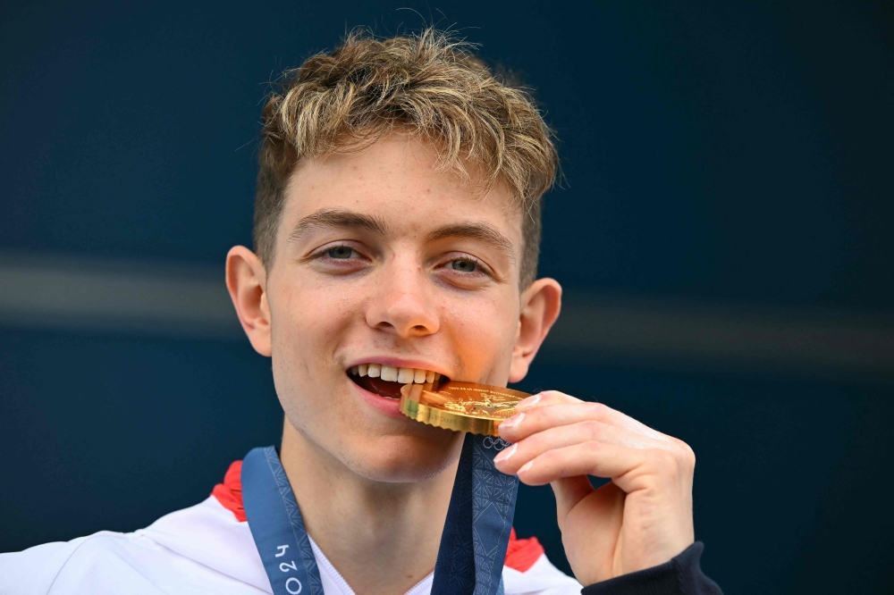 British gold medalist Toby Roberts poses on the podium after the men's sport climbing lead final during the Paris 2024 Olympic Games at Le Bourget Sport Climbing Venue in Le Bourget on August 9, 2024. (Photo by Fabrice COFFRINI / AFP)
