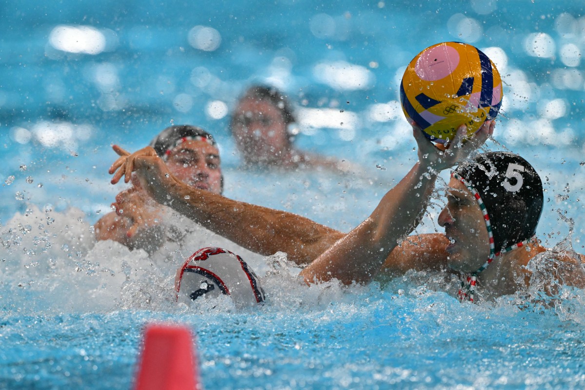 US' #01 Adrian Weinberg is marked by Hungary's #05 Marton Vamos in the men's water polo bronze medal match between the USA and Hungary during the Paris 2024 Olympic Games at the Paris La Defense Arena in Paris on August 11, 2024. Photo by Andreas SOLARO / AFP.