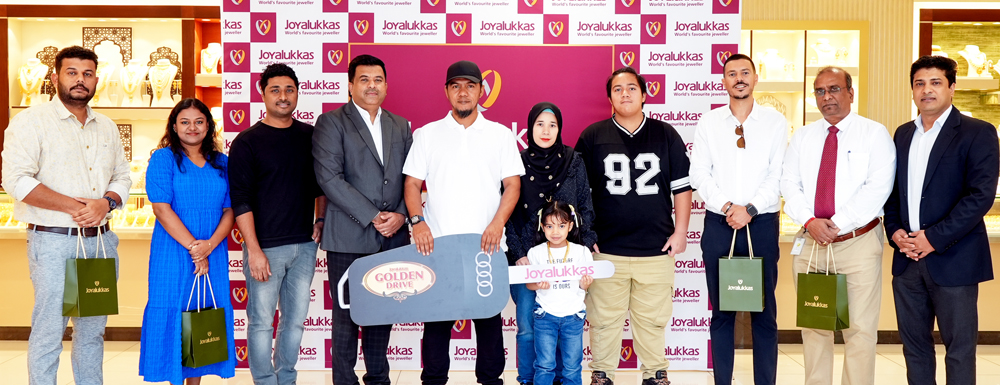 Joyalukkas personnel handing over keys of a brand-new Audi Q3 to the Golden Drive promotion winner, Mohd Irwan Bin Isa. Another 14 winners won 22-karat gold bars.