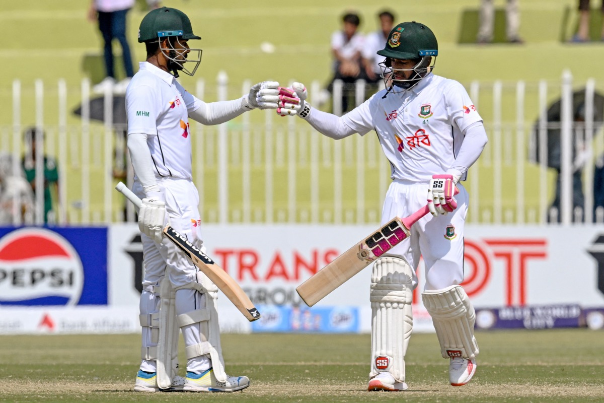 Bangladesh's Mushfiqur Rahim (R) and Mehidy Hasan Miraz bump their fists during the fourth day of the first Test cricket match between Pakistan and Bangladesh at the Rawalpindi Cricket Stadium in Rawalpindi on August 24, 2024. (Photo by Farooq NAEEM / AFP)
