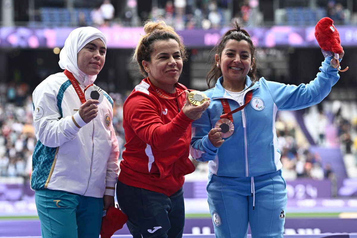 Silver medalist Uzbekistan's Kubaro Khakimova (L), gold medalist Tunisia's Raoua Tlili and bronze medalist Argentine's Antonella Ruiz Diaz celebrate on the podium during the victory ceremony for the women's F41 shot put final athletics event at the Paris 2024 Paralympic Games at Stade de France in Saint-Denis, north of Paris on August 30, 2024. Photo by JULIEN DE ROSA / AFP