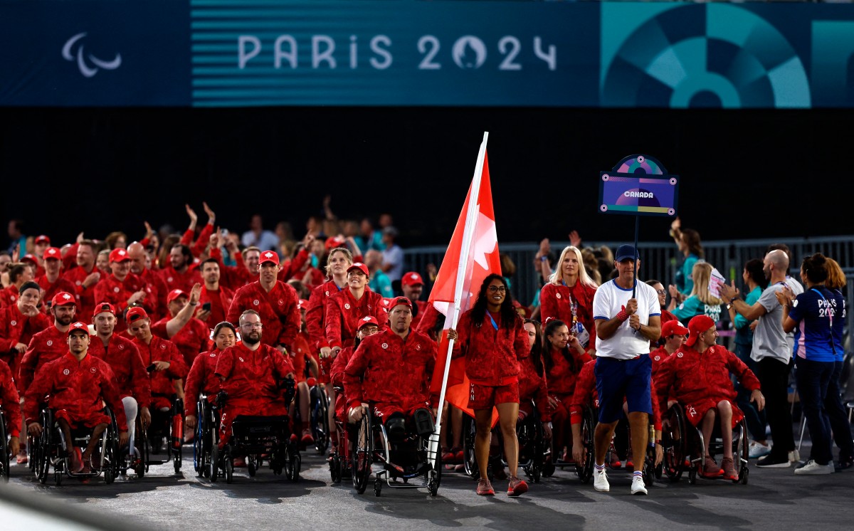 Canada's flagbearers and Paralympic athletes Patrick Anderson (C-L) and Katarina Roxon (C-R) parade during the Paris 2024 Paralympic Games Opening Ceremony in Paris on August 28, 2024. Photo by Gonzalo Fuentes / POOL / AFP.