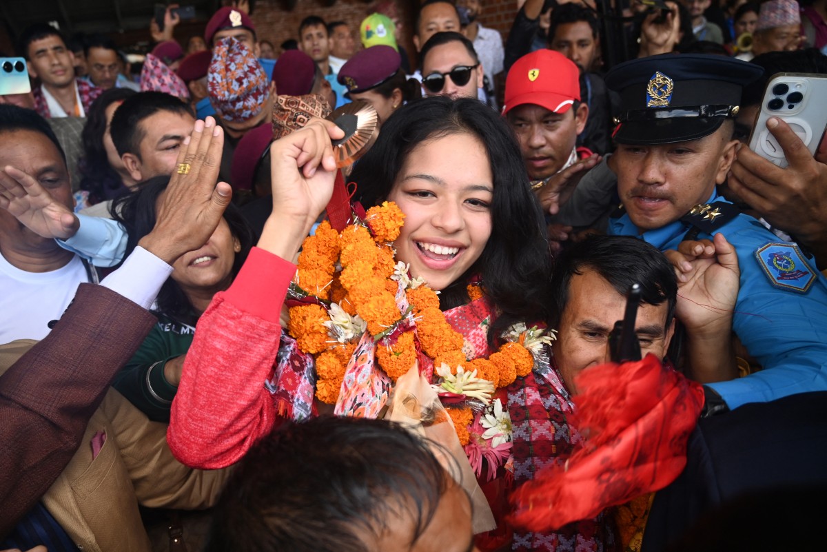 Paris 2024 Paralympic Games taekwondo bronze medallist Palesha Goverdhan greets the crowd upon her arrival at the Tribhuvan International Airport in Kathmandu on September 4, 2024. Photo by Prakash MATHEMA / AFP.