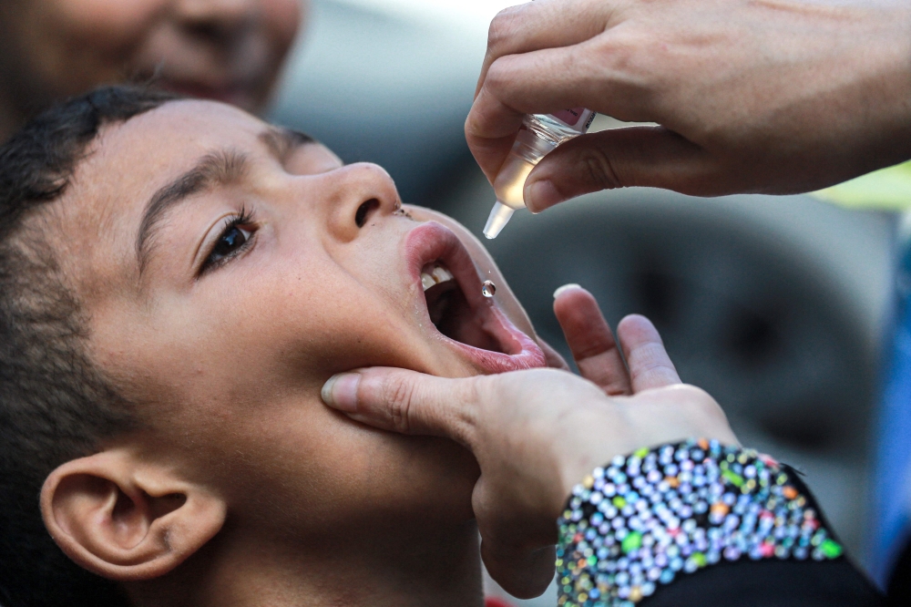 A child receives a vaccination for polio in Khan Yunis in the southern Gaza Strip on September 5, 2024. (Photo by Bashar Taleb / AFP)

