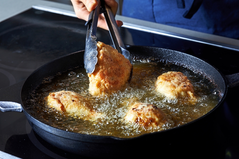 Gently but confidently add food to hot oil, without dropping it in from afar. (Photo by Stacy Zarin Goldberg for The Washington Post)