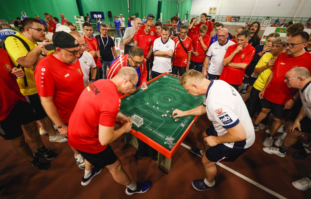 People look on as England veteran player Darren Clarke (R) takes a shot against Belgium during the Subbuteo World Cup on September 22, 2024. (Photo by Adrian Dennis / AFP)