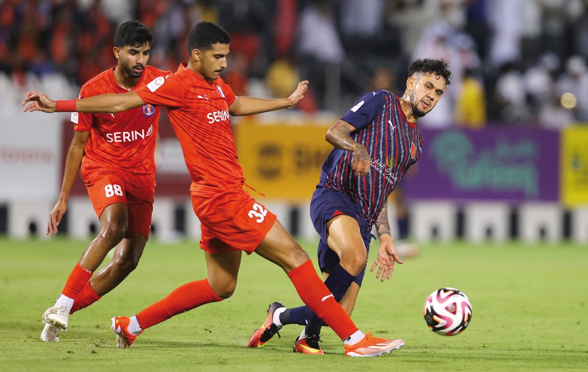 Al Shahania's Ali Al Amri (centre) vies for the ball with Al Duhail's Edmilson Junior during their Ooredoo Stars League Round 6 match. 