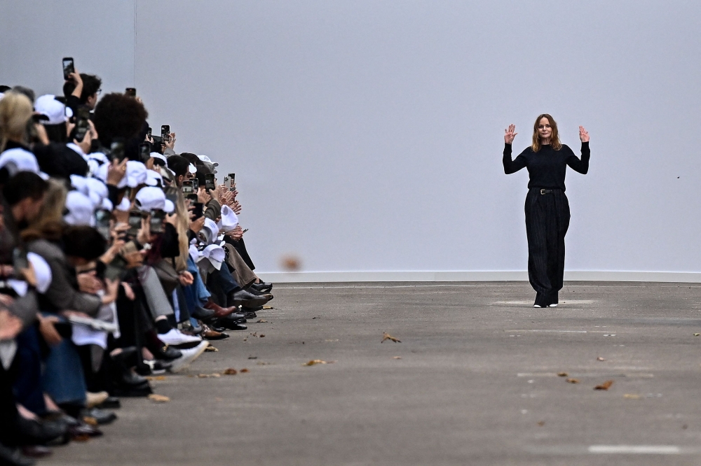 British fashion designer Stella McCartney (C) acknowledges the audience at the end of her Women Ready-to-wear Spring-Summer 2025 collection as part of the Paris Fashion Week, in Paris on September 30, 2024. (Photo by JULIEN DE ROSA / AFP)