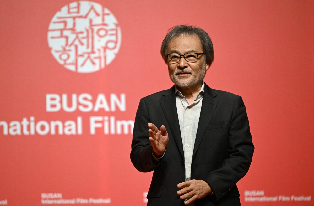 Japanese film director Kiyoshi Kurosawa gestures as he poses for photos at the 29th Busan International Film Festival (BIFF) in Busan on October 3, 2024. (Photo by Jung Yeon-je / AFP)