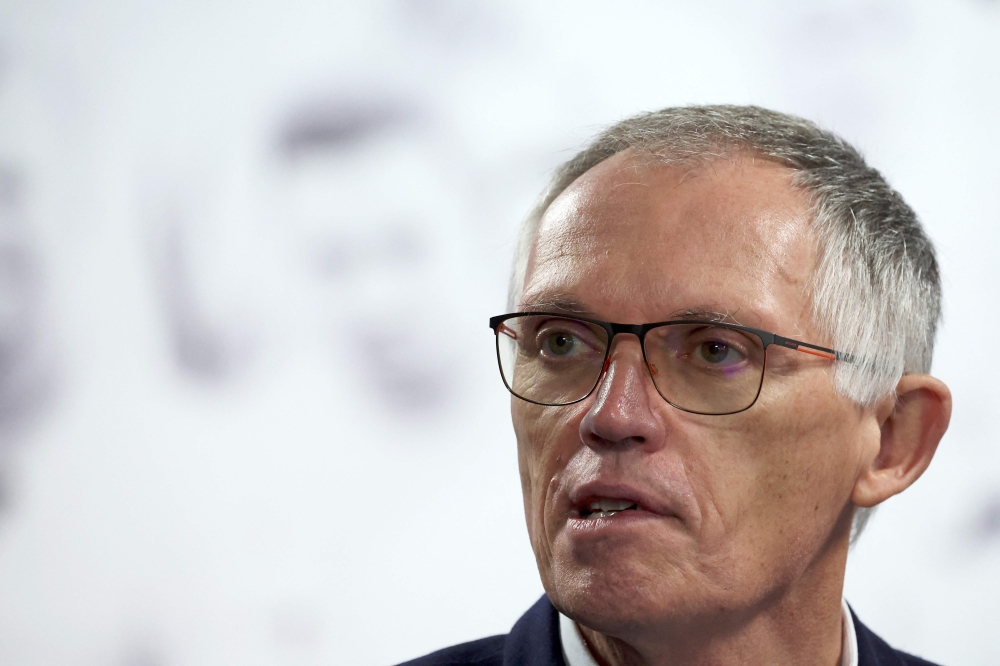 Stellantis CEO Carlos Tavares (C) answers journalists' questions after attending a visit of the production line of the new Peugeot e-3008 and e-5008 electric car at the Stellantis car factory in Sochaux, eastern France on October 3, 2024. (Photo by FREDERICK FLORIN / AFP)