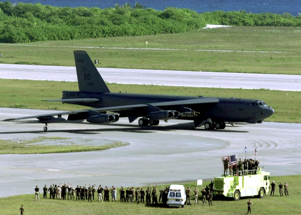 US Air Force ground crew members wave at a B-52H Stratofortress bomber as it taxis in Diego Garcia military base for take off on a strike mission against Afghanistan in Diego Garcia on October 07, 2001. (Photo by DoD / AFP)