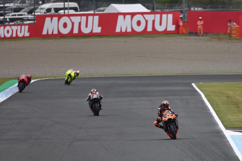 Red Bull KTM Factory Racing rider Brad Binder of South Africa (R) leads the pack during the MotoGP class practice 1 session of MotoGP Japanese Grand Prix at the Mobility Resort Motegi in Motegi, Tochigi prefecture on October 4, 2024. (Photo by Toshifumi KITAMURA / AFP)