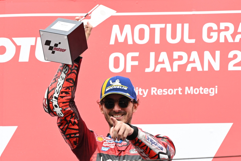 Ducati Lenovo Team rider Francesco Bagnaia of Italy raises his victory trophy on the MotoGP class race podium of MotoGP Japanese Grand Prix on October 6, 2024. (Photo by Toshifumi Kitamura / AFP)