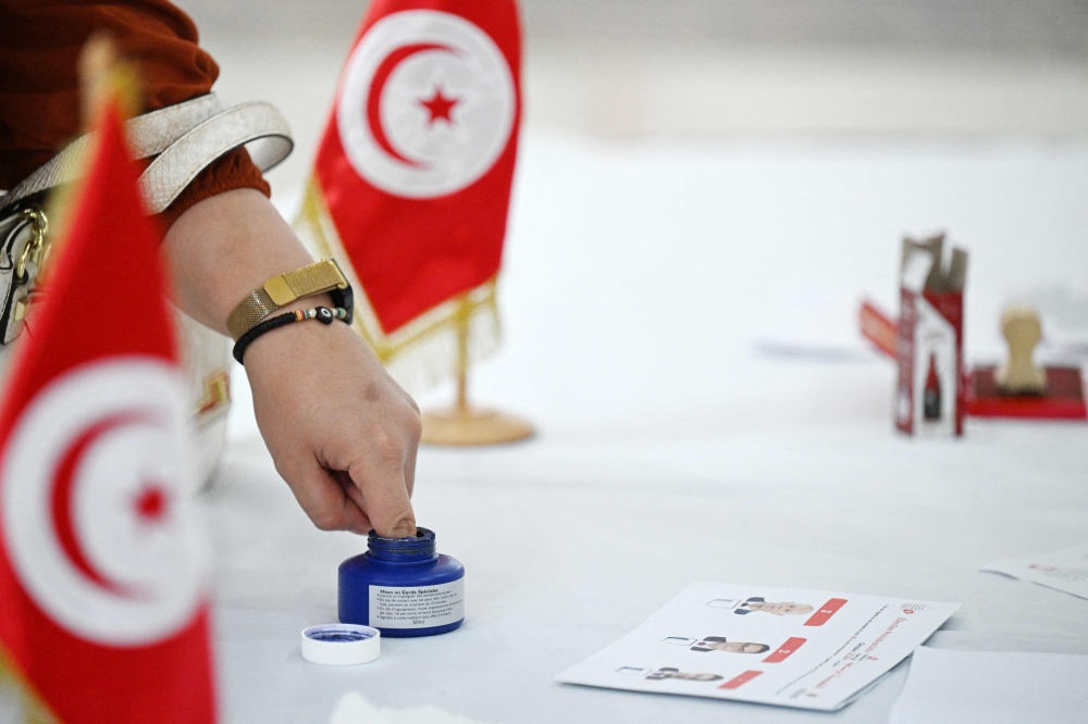 A Tunisian national living in Kuwait dips her finger in ink after casting her vote for the presidential elections at the Tunisian embassy in Kuwait City on October 6, 2024. (Photo by Yasser Al-Zayyat / AFP)