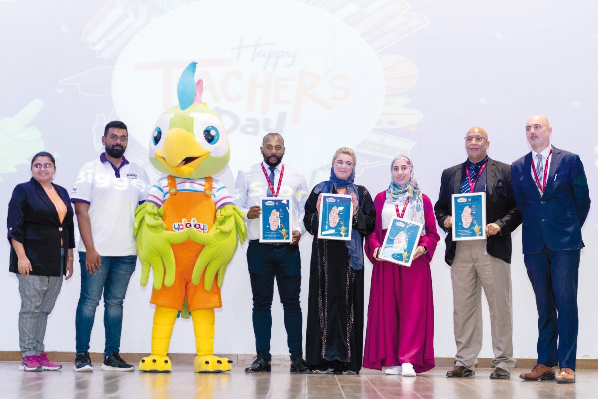 A group of Doha Academy teachers and staff with a mascot on the occasion.