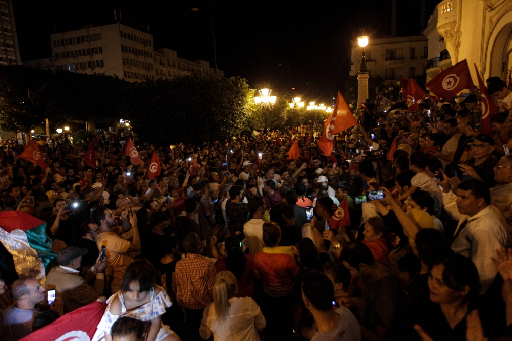 Supporters of Tunisia's President celebrate after the announcement of the first estimates in favor of the incumbent President, during Tunisia's Presidential election, on the Avenue Habib Bourguiba in Tunis on October 6, 2024. (Photo by YASSINE MAHJOUB / AFP)
