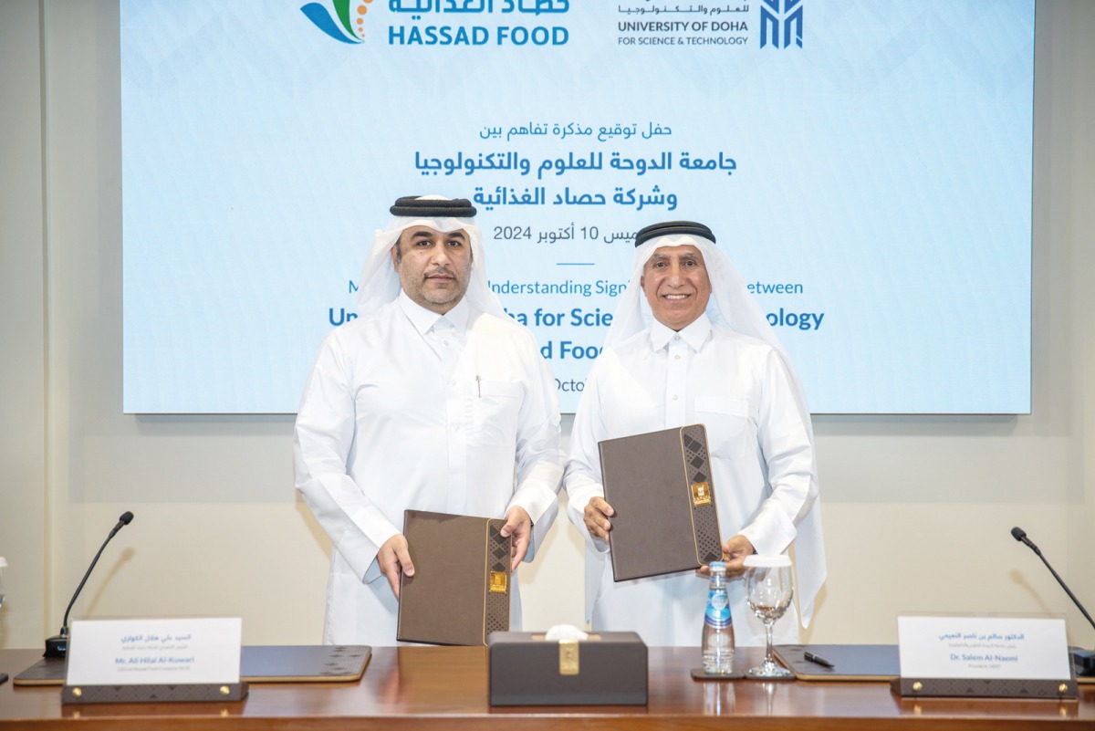 President of UDST Dr. Salem Al Naemi (right) and Chief Executive Officer of Hassad Food Eng. Ali Hilal Al Kuwari exchanging documents after signing an agreement.