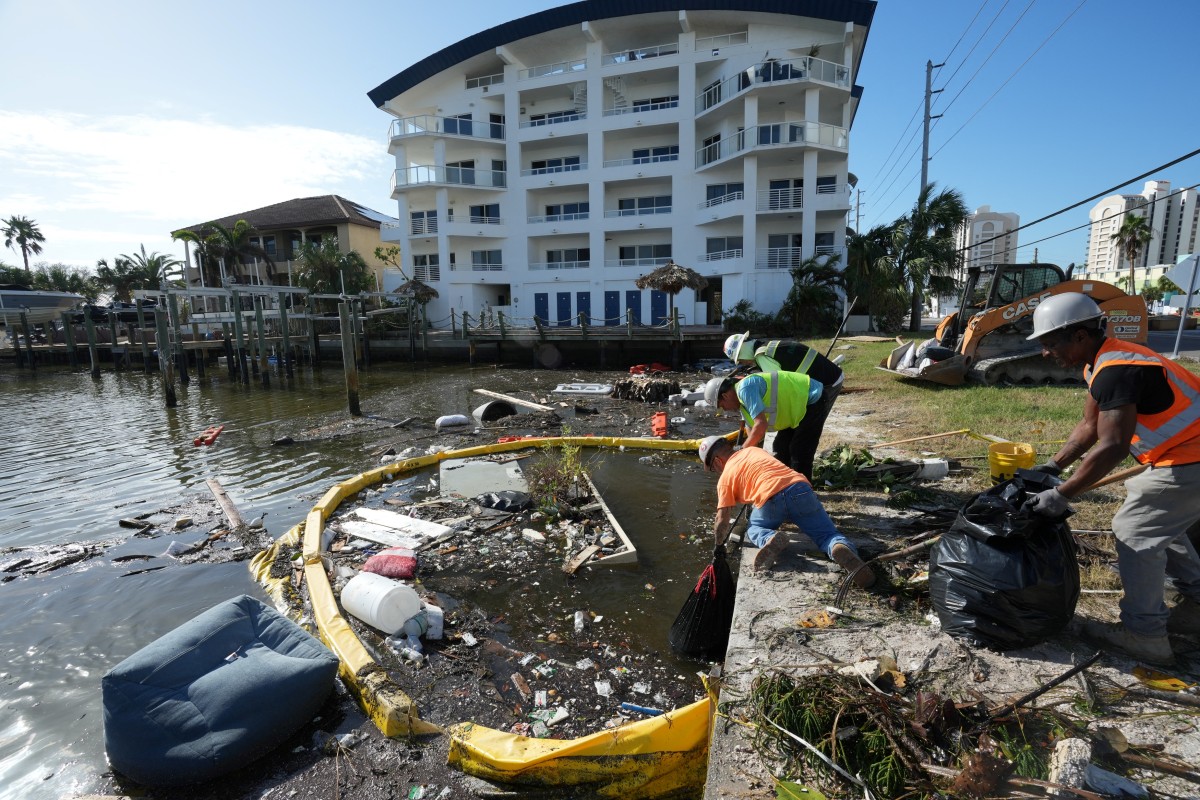 Contractors work to remove garbage and debris from Clearwater Bay in Clearwater Beach, Florida, following the passage of Hurricane Milton on October 11, 2024. 