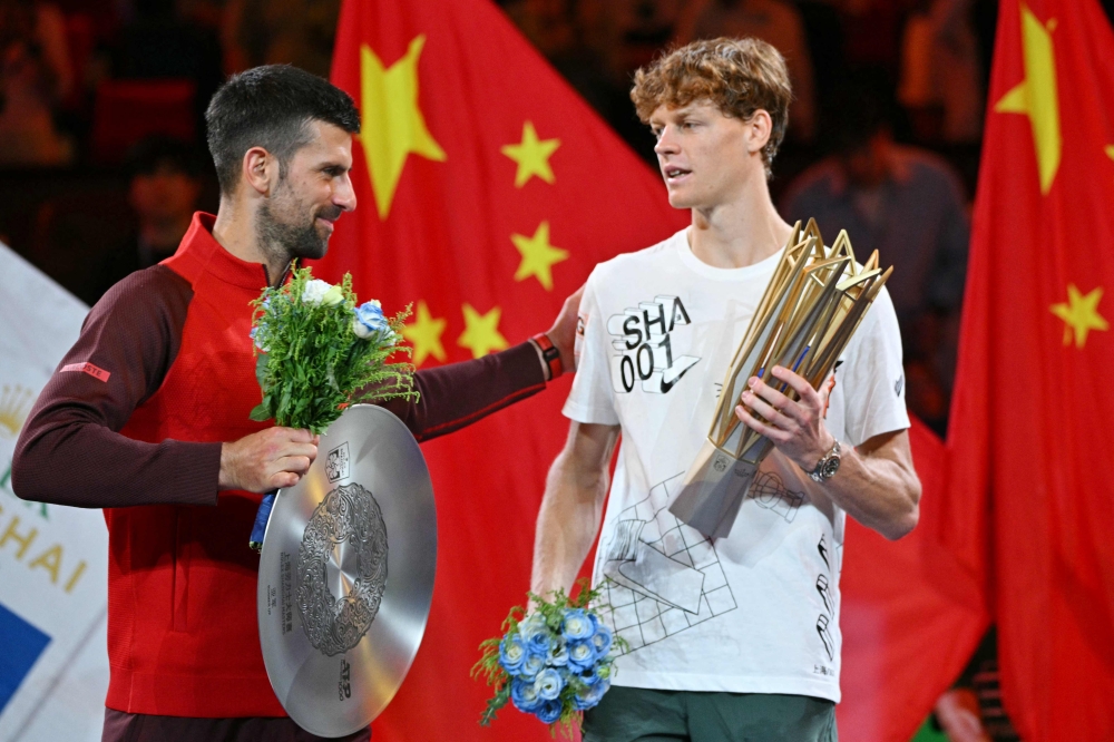 Italy's Jannik Sinner (R) is greeted by Serbia's Novak Djokovic after Sinner won their men's singles final match at the Shanghai Masters tennis tournament on October 13, 2024. (Photo by Hector Retamal / AFP)