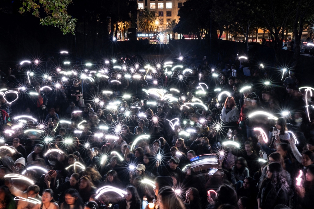 Fans light cellphones as they pay tribute to the late British singer Liam Payne at the Revolucion monument in Mexico City on October 17, 2024. Photo by Yuri CORTEZ / AFP